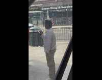 Guy balances box and water bottle on head 