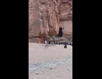 Woman rides a camel at the canyon