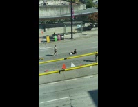 Woman black dress sits in the middle of the street