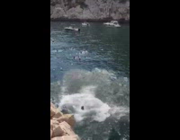 Guy front flips into water from cliff 