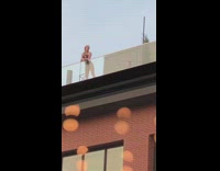 Woman black bikini taught by her friend to pose on the rooftop