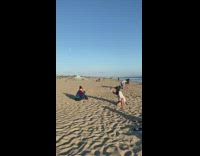 Girl sit sand phone call beach sunglasses