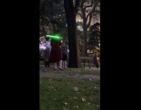 Man and woman pose with light saber