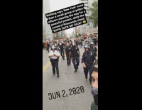 Peaceful protest crowd marches behind cops police 