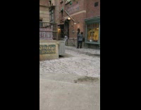 Girl poses for photo by brick wall