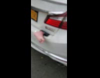 fake foot sticking out of back of white car