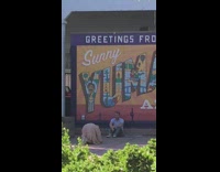 Guy collared shirt sit beside greeting poster