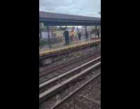 Two masked men have a staredown across train platform