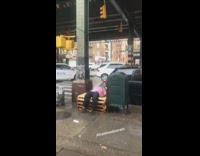 man in pink shirt laying on pallet in the rain