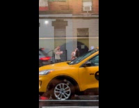 Woman sexy poses on the rainy sidewalk