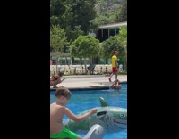 Woman in black bikini poses at the poolside