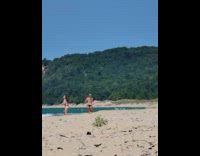 Two women in bikini run at beach