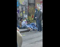 People doing puppet show on sidewalk lying down