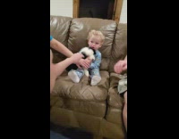 Baby sit at the couch and massage the puppy 