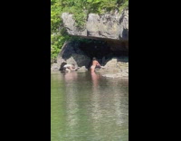 Woman in white bikini poses at the river cave