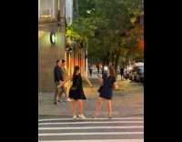 Two women practice dance street wait traffic light 
