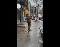 Lady skis across sidewalk without snow 