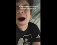 Guy in black shirt rolling around bed back hurts 