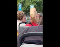 Man wearing CVS paper bag as hat 