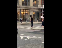 Man crossing street with bearded dragon on back