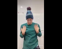 Guy wearing green sweater dances in bathroom  