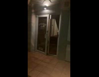 Guy on sidewalk at night chased by guy in costume