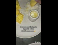 Dipping pasta inside of butter and parmesan