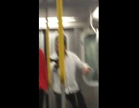 Guy in white shirt and red sweater fighting with swords on subway train