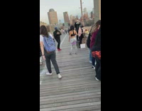 Woman snake pants do squats brooklyn bridge