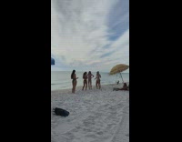 Four women in bikini take turns to dance at the beach