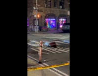 Shirtless man lays down beside smoking sewer