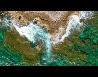 Slow motion top view waves crash into shore