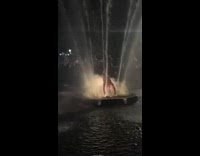 Guy does backbend over water fountain 