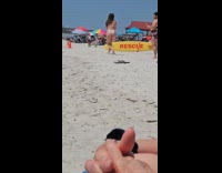 Collab IITW - Woman in bikini kneels on sand while friend takes picture from behind