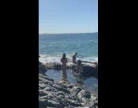 Three women bikini beach rocks waves photoshoot