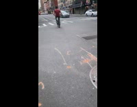 Red shirt guy rides bicycle backwards 