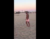 Guy pink shorts arm tattoo walk beach