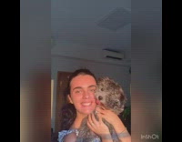 Girl holds up small brown dog sunny