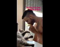 Collab PLC - Man shirtless plays with cat on table