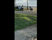 Man in white shirt raps at the park bench