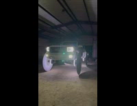 White truck with large circular saws replacing wheels