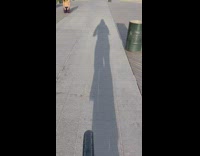 Guy Bikes Passed Guy with Eyes Closed Kneeling on Ground 