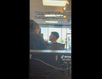 Man Looks Away at Camera as he Take Haircut