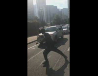 Homeless man asks for money on street with cardboard sign in jordans shoes