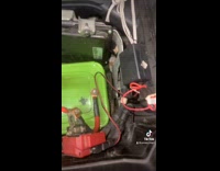 Men Checks Out Homemade Car Battery in Container