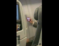 Collab IITW - Guy in suit records himself with big eyes mouth filter on airplane