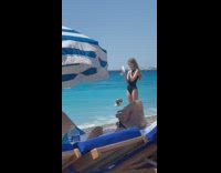 Teenage daughter takes photos of mom on sand 