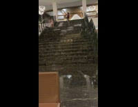 Woman pink dress pose at hotel stairs