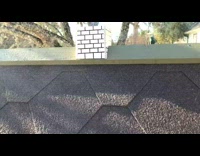 Dog sleeps inside the dog house with some from chimney and a flag