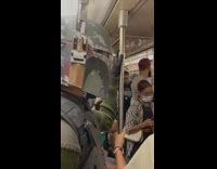 Guy in green on train wears sci fi helmet 